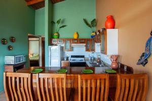 uma cozinha com uma mesa com cadeiras e um frigorífico em Coco Joya Condo - pool with 180 ocean view - all in walking distance em Coco
