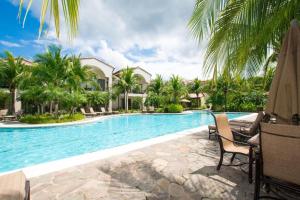 una piscina con palmeras y un complejo en Ground-Floor Unit, Terrace with Direct Access to Pool in Coco, en Coco