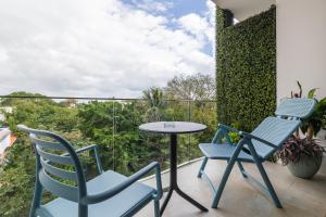 un patio con 2 sillas y una mesa en el balcón en Xaha Condo, en Playa del Carmen