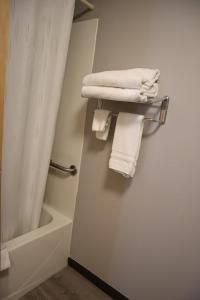 a white towel hanging on a white wall next to a white sink at Express Inn & Suites Eugene in Eugene