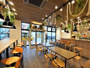 a restaurant with wooden tables and chairs and windows at Green Rich Hotel Yonago Ekimae (Artificial hot spring Futamata Yunohana) in Yonago