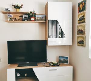 TV de pantalla plana en la parte superior de un armario blanco en Cozy Corner Apartments - Free parking & Wi-fi, en Ćuprija
