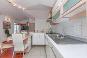 a kitchen with white cabinets and a sink at Apartments Mia in Omiš +25 photos