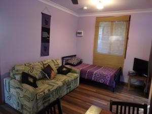 uma sala de estar com um sofá e uma cama em Teretre Cabins Nimbin em Nimbin