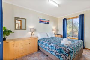 un dormitorio con una cama y una ventana en Venus Bay Beachfront Tourist Park South Australia, en Venus Bay