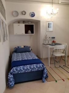 a bedroom with a bed and a desk and a table at Alle Grottine in Sciacca