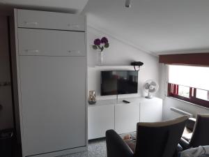 a living room with a tv on a white wall at Ático tipo Loft centro de Mugardos in Mugardos