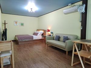 a living room with a bed and a couch at Charm Pension in Gapyeong
