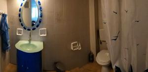 a bathroom with a sink and a mirror and a toilet at Yacht Front Apartment - No 1 in Ios Chora