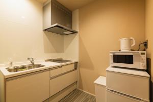 Una pequeña cocina con fregadero y microondas. en GRAND BASE Fukuoka Tenjin, en Fukuoka 22 fotos más