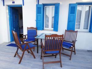 four chairs and a table with blue cushions on a patio at Yacht Front Apartment - No 1 in Ios Chora