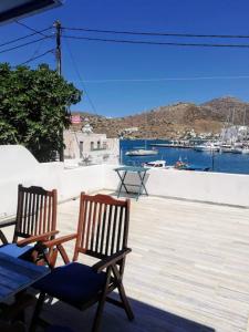 2 Stühle auf einer Terrasse mit Blick auf das Wasser in der Unterkunft Yacht Front Apartment - No 1 in Chora, Ios