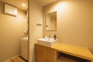 a bathroom with a sink and a mirror at GRAND BASE Fukuoka Tenjin in Fukuoka