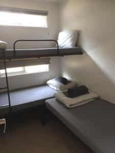 two bunk beds in a small room with a window at Del Rio Riverside Resort in Wisemans Ferry