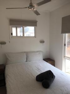 a bedroom with a bed with a hat on it at Del Rio Riverside Resort in Wisemans Ferry