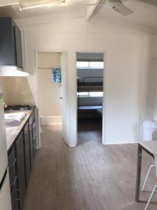 a kitchen with a door open to a room at Del Rio Riverside Resort in Wisemans Ferry