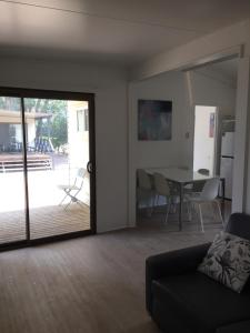 a living room with a sliding glass door and a table at Del Rio Riverside Resort in Wisemans Ferry