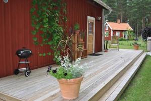 a wooden deck with plants on the side of a house at Bli en del av Vråka by in Edsbruk