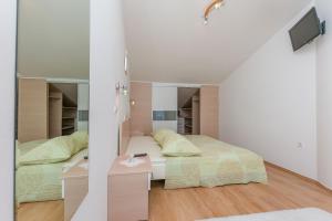a bedroom with two beds and a mirror at Apartments Mia in Omiš
