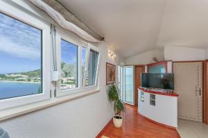 a living room with windows and a tv at Apartments Mia in Omiš