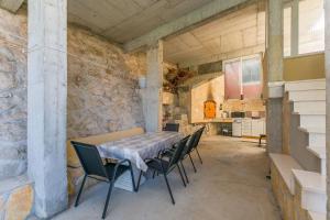 a table and chairs in a room with a stone wall at Apartments Mia in Omiš