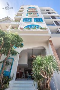 a building with stairs and palm trees in front of it at Shin Sam Boutique Hotel in Vung Tau