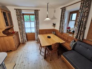 a dining room with a table and a couch at Glögglhof in Lana