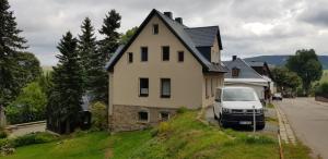 a white van parked in front of a house at DIREKT AM SKIHANG! Müller Ferienwohnungen in Kurort Oberwiesenthal