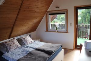 ein Schlafzimmer mit einem Bett und zwei Fenstern in der Unterkunft Ferienhaus Geli in Wernigerode