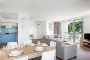 een woonkamer met een tafel en een bank bij BreakFree Diamond Beach in Gold Coast