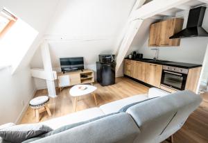 een woonkamer met een bank en een keuken bij Le Relais De La Ravine in Vernon
