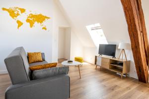 ein Wohnzimmer mit einem Sofa und einer Weltkarte an der Wand in der Unterkunft Le Relais De La Ravine in Vernon