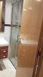 łazienka z prysznicem z drewnianymi drzwiami w obiekcie Marina d'Or, apartamentos Valparaíso w mieście Oropesa del Mar