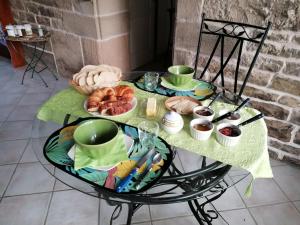 - une table avec un plateau de pain et des viennoiseries dans l'établissement Le Champ, à Le Clerjus