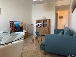 sala de estar con sofá azul y mesa de cristal en Affittacamere San Giorgio, en Manarola