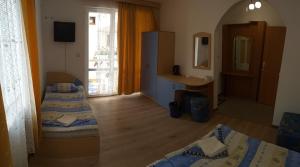 a room with two beds and a sink and a window at Primorsko Apartments in Primorsko