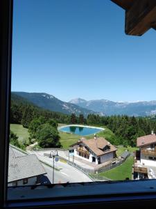 una ventana con vistas a una casa con piscina en Hotel B&B Francolini, en Folgaria