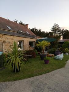 a house with a yard with plants and an umbrella at Aux Couleurs de la Baie in Cherrueix +35 photos
