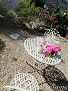 a white table with pink flowers on top of it at Gîte Pierre et Marie in Mellecey