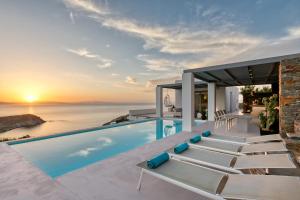 a villa with a infinity pool with the sunset at Villa Meli in Otzias