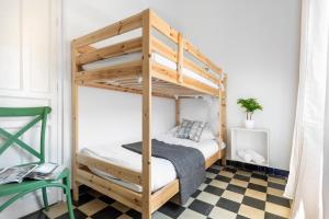 Ce lit superposé se trouve dans un dortoir doté d'un sol en damier. dans l'établissement HSH Suites Campana, à Séville