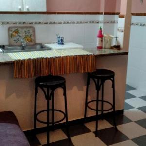 a kitchen with two bar stools and a sink at La Isabelita in Andújar +49 photos