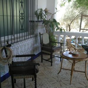 a room with chairs and a table on a porch at La Isabelita in Andújar