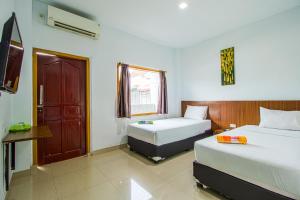 a hotel room with two beds and a window at My Home Aceh in Banda Aceh