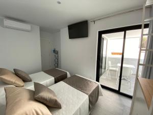 a bedroom with two beds and a sliding glass door at Flying La Palma - Sostenible in Los Llanos de Aridane