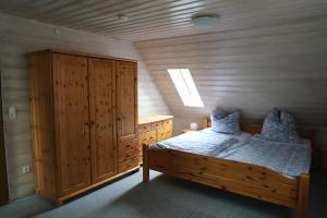 um quarto com uma cama de madeira e um armário de madeira em Ferienhaus Irene em Friedrichshafen