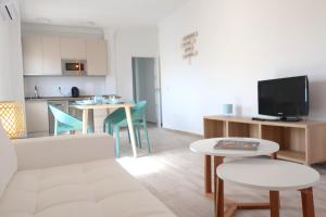 - un salon avec un canapé, une table et des chaises dans l'établissement Apartamento La Playa, à Nerja