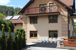 a building with chairs and a balcony on it at Dom w Górach "TRESNA" in Tresna