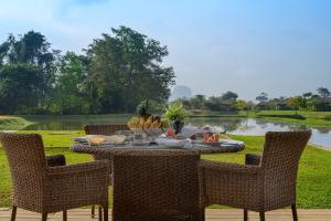 a table with a bowl of fruit on it next to a lake at Water Garden Sigiriya in Sigiriya