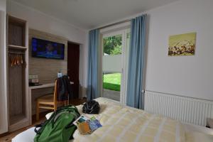 a bedroom with a bed with a green bag on it at Hotel Café Wahlde Restaurant in Grapperhausen